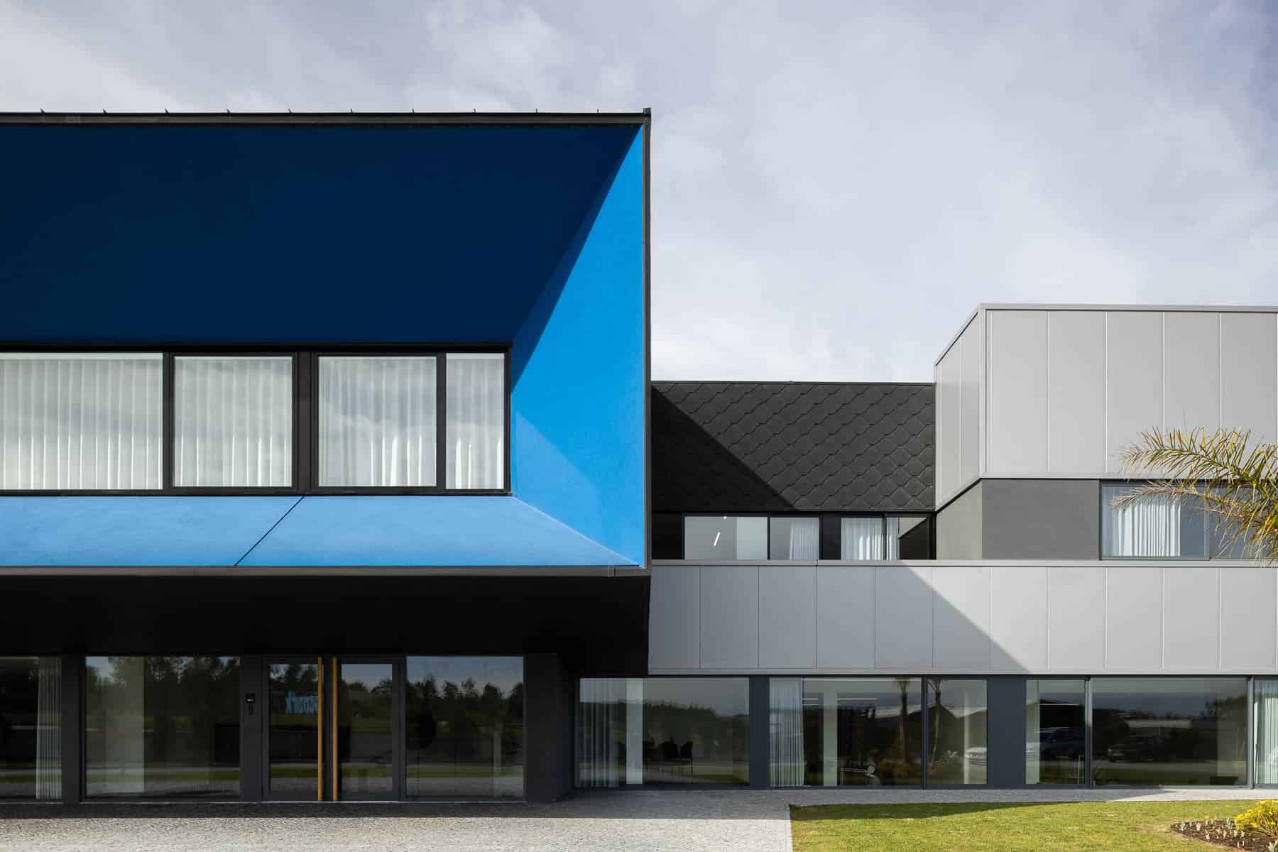 Contemporary modern architecture building with geometric design, vibrant blue exterior, large windows, and minimalist aesthetic, ideal for architecture art designs.