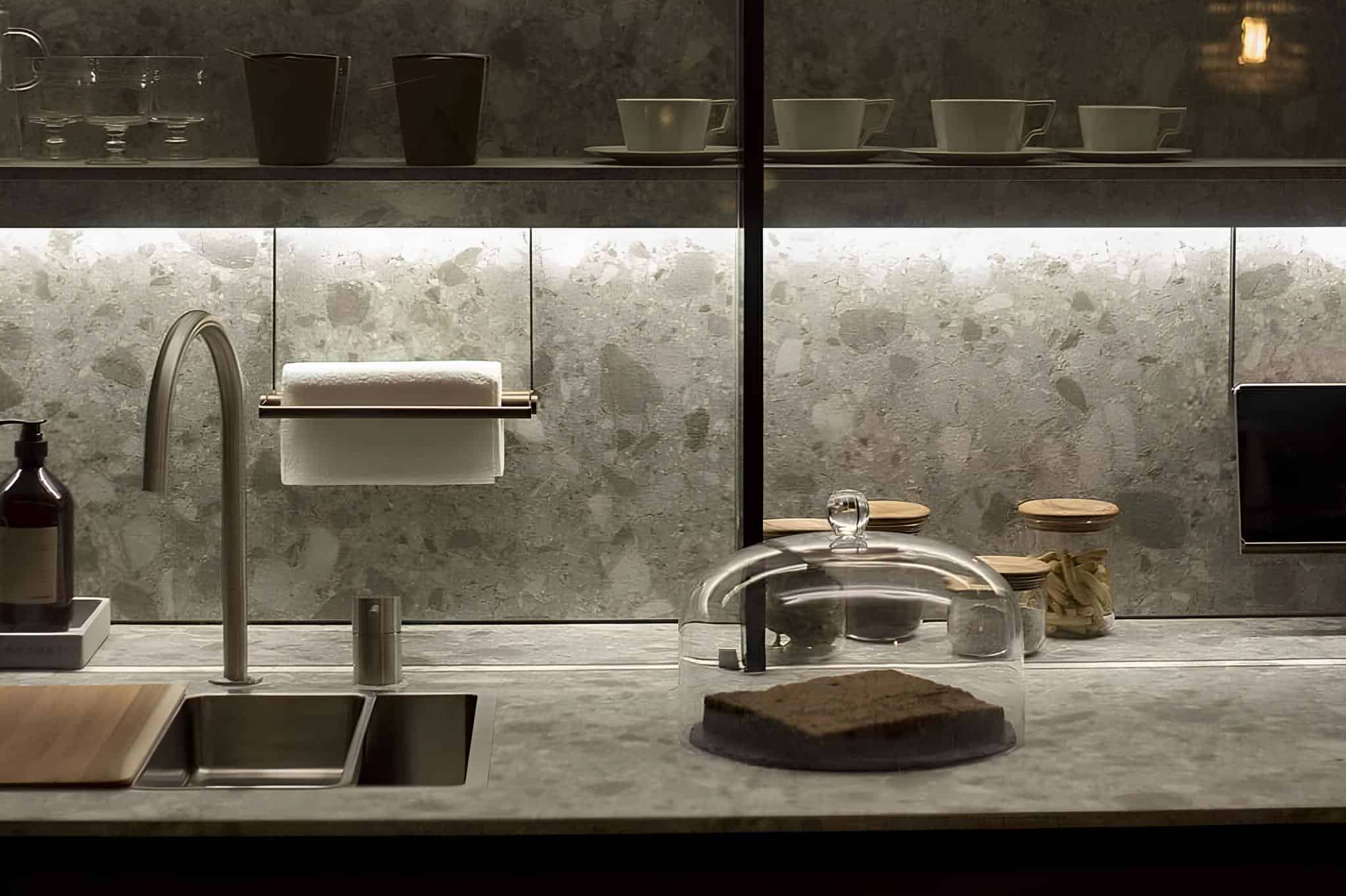 Dark-toned kitchen with gray stone backsplash and under-cabinet lighting