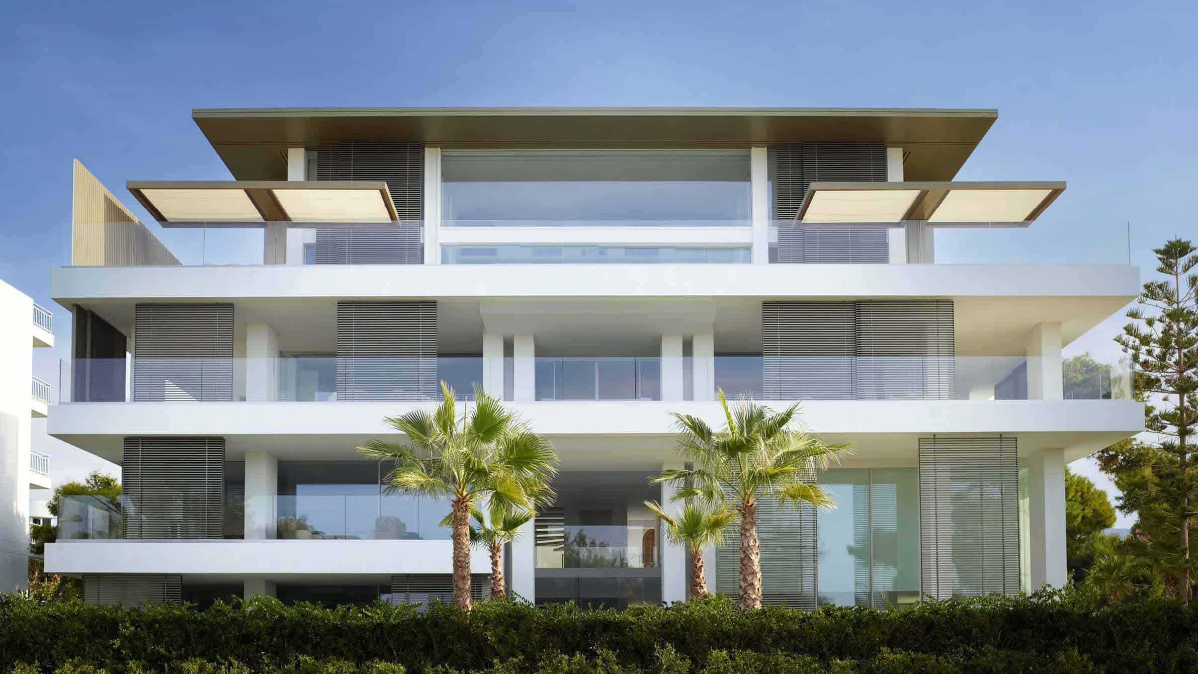 Modern luxury residential building with sleek architecture, extensive glass windows, and lush landscaping, exemplifying contemporary design and innovative architectural art.