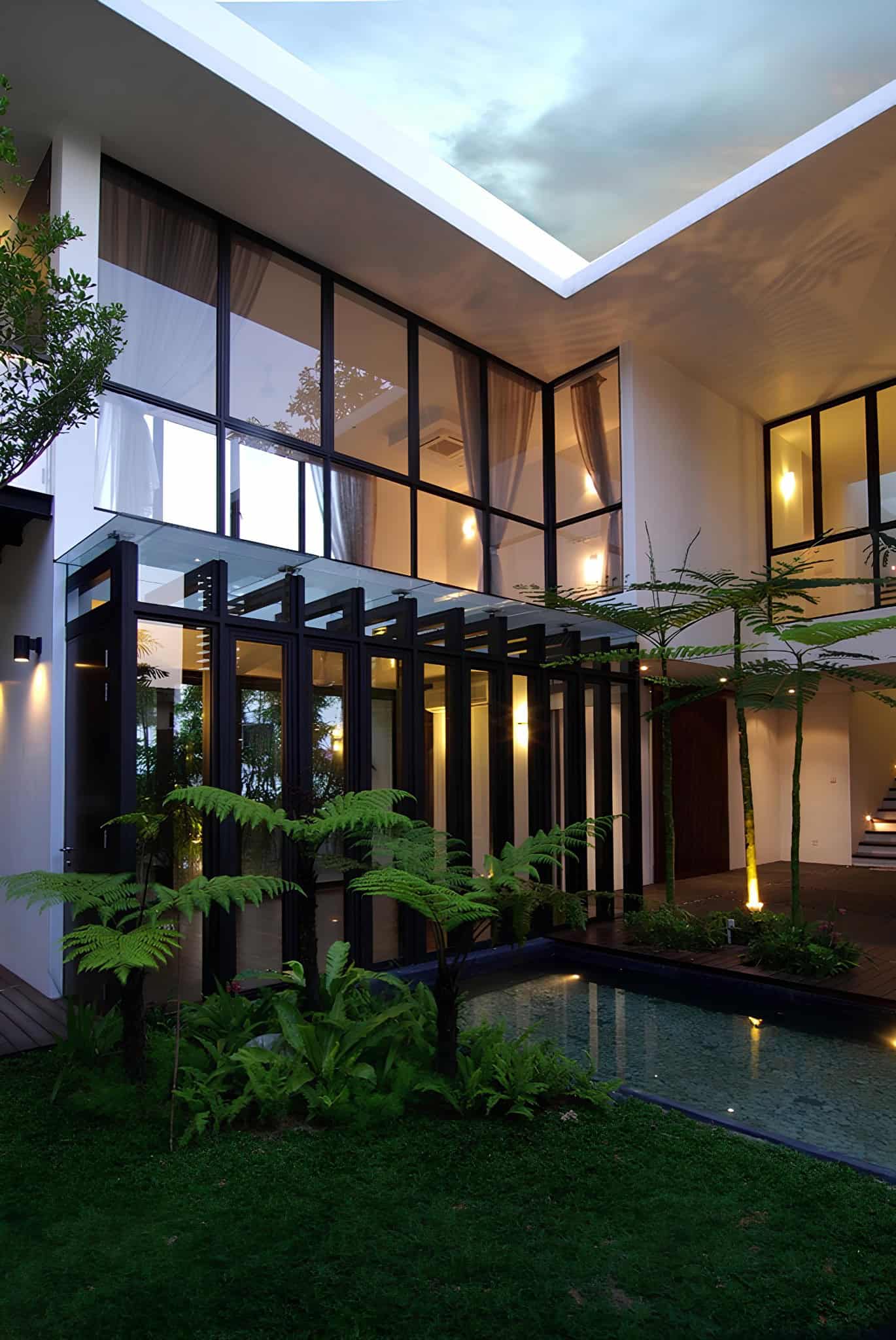 Jalan Merlimau Evening Courtyard Lights Twilight courtyard view of Jalan Merlimau with warm ambient lighting and water reflections.