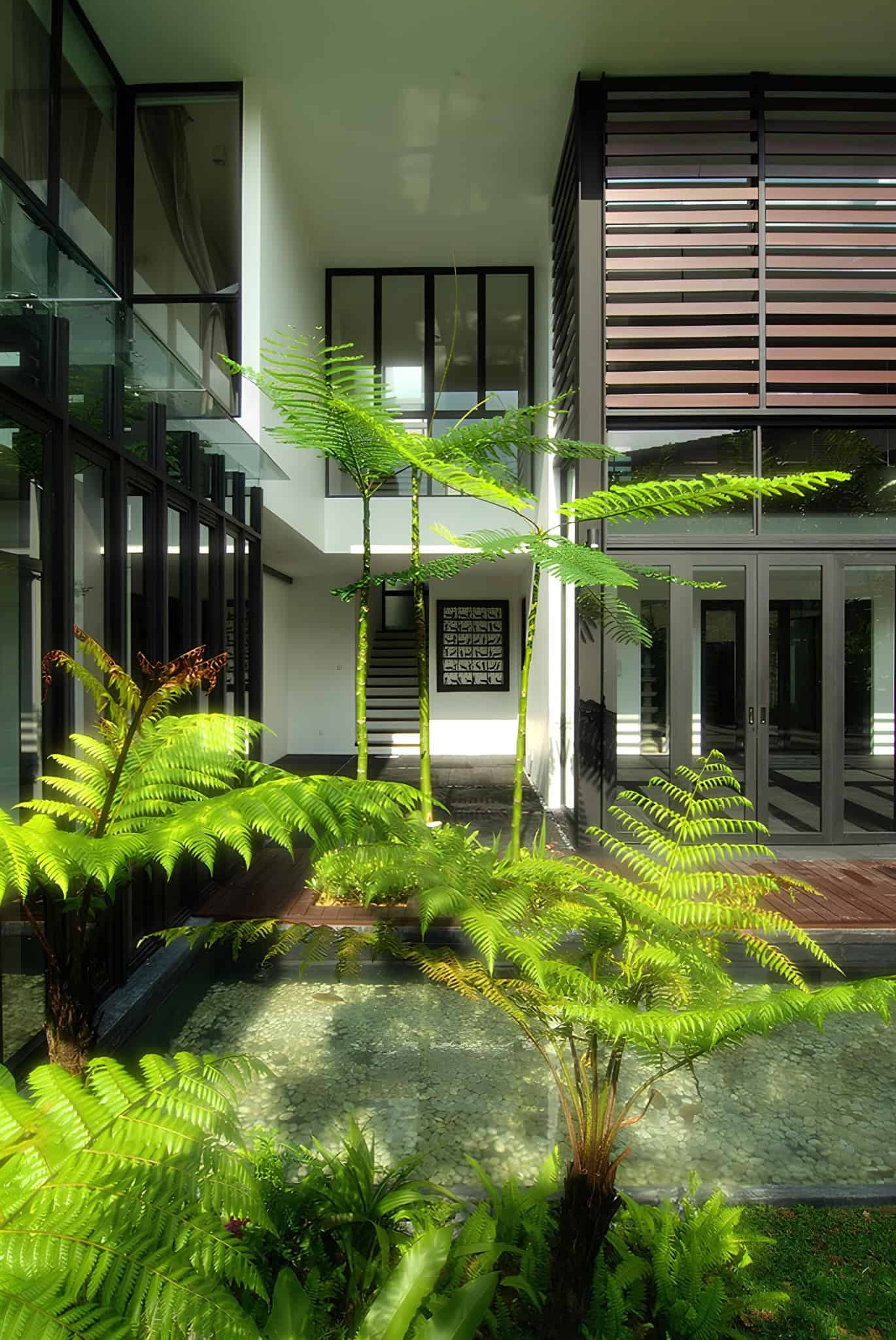 Jalan Merlimau Evening Courtyard Reflection Evening view of Jalan Merlimau courtyard with reflections on the water and illuminated interiors.