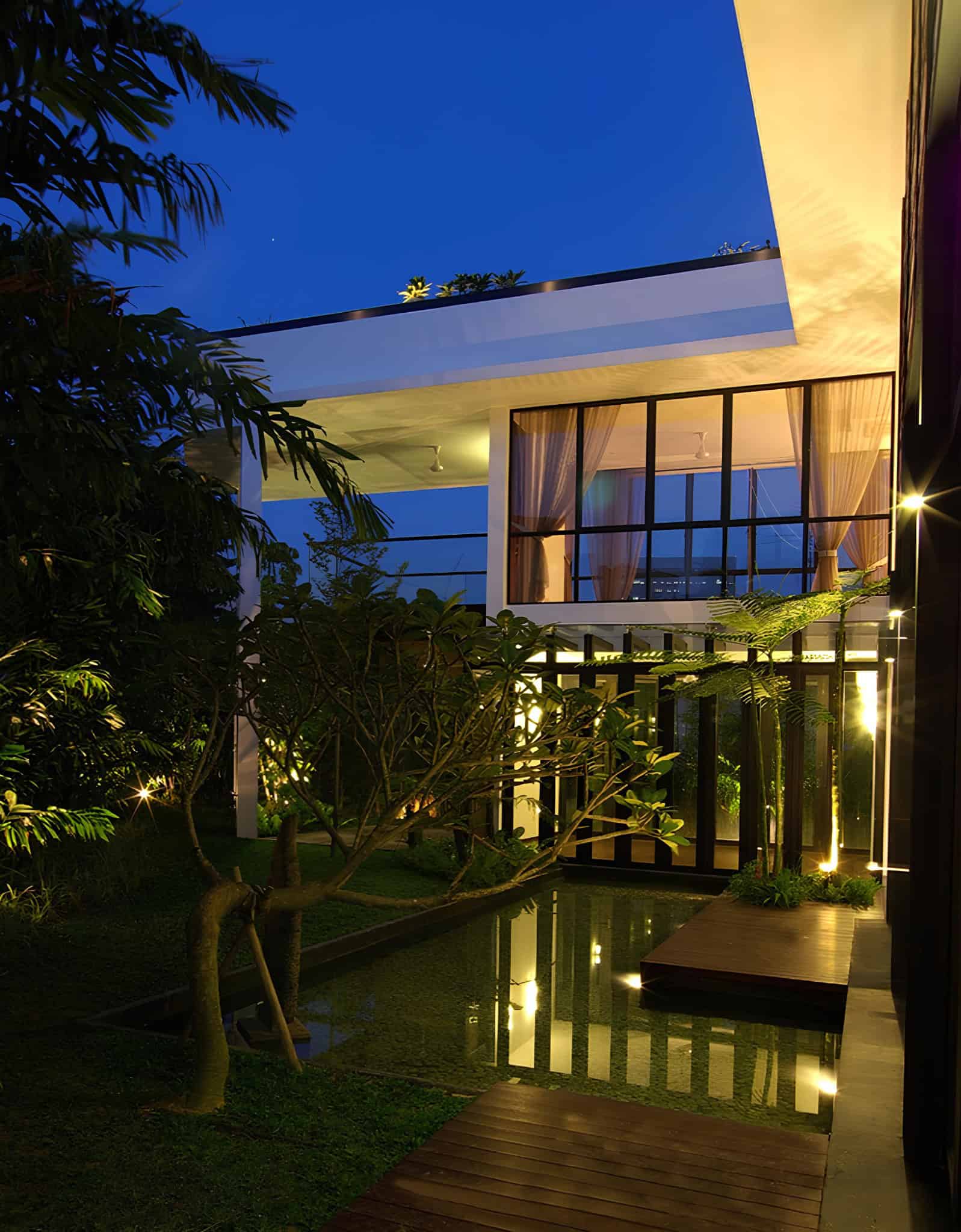 Jalan Merlimau Evening Garden View Evening view of the reflective garden pond and lit interiors of Jalan Merlimau.