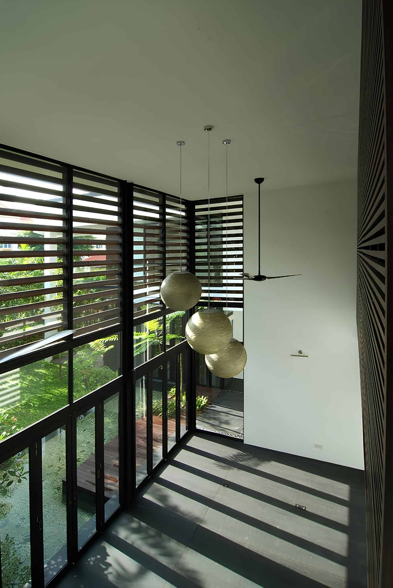 Jalan Merlimau Louvered Glass Corner Angled view of sunlight casting shadows through louvered windows onto the floor.