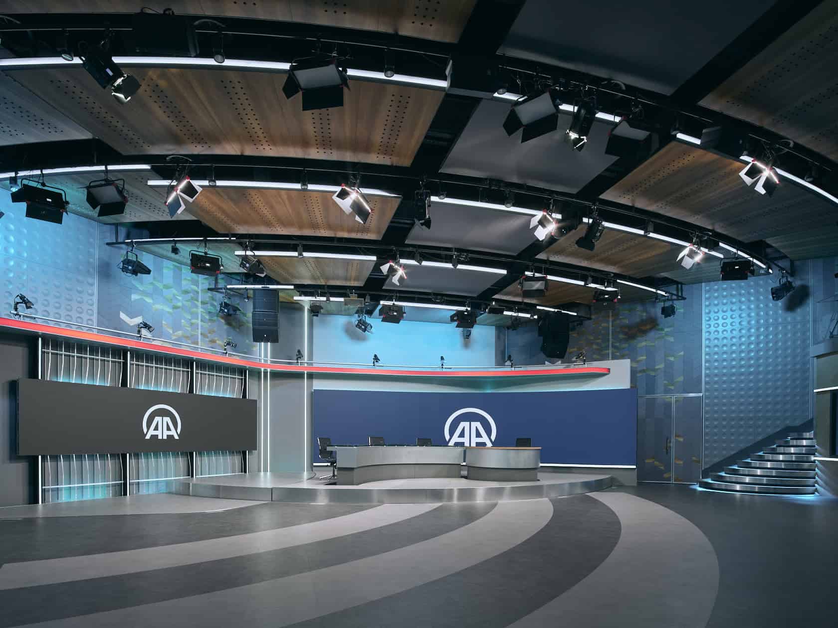 Modern television studio with advanced lighting and sound equipment, featuring sleek curved design, digital screens, and contemporary architecture for professional broadcasting.
