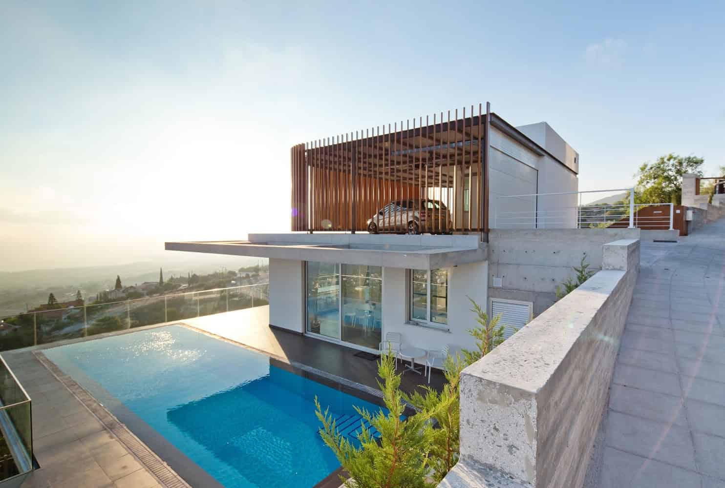 Modern luxury house with outdoor pool overlooking scenic landscape and contemporary architectural design.