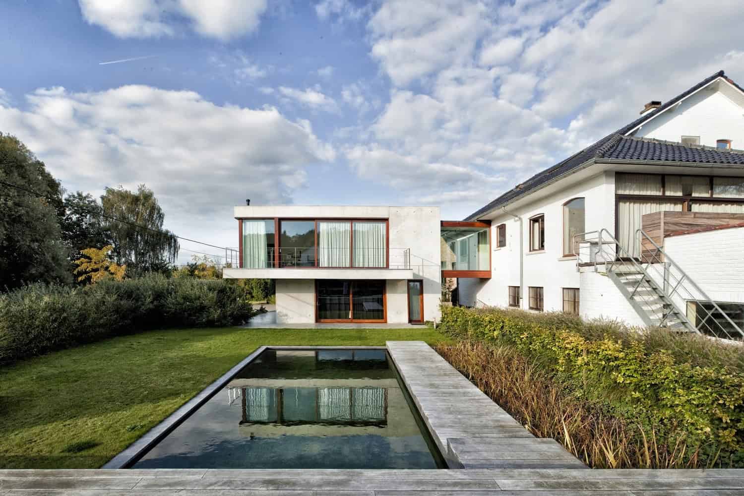 Contemporary modern house architecture with sleek design, large windows, and minimalist style featuring a well-maintained garden and reflecting pool, highlighting innovative residential architecture.