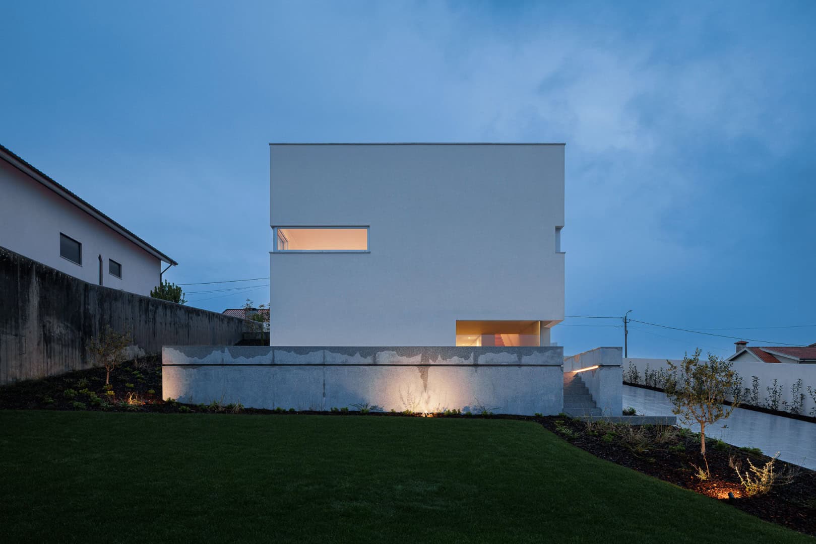 Contemporary minimalist white house with clean lines and modern architecture at dusk, featuring sleek geometric design and subtle lighting accents for stylish urban residential architecture.