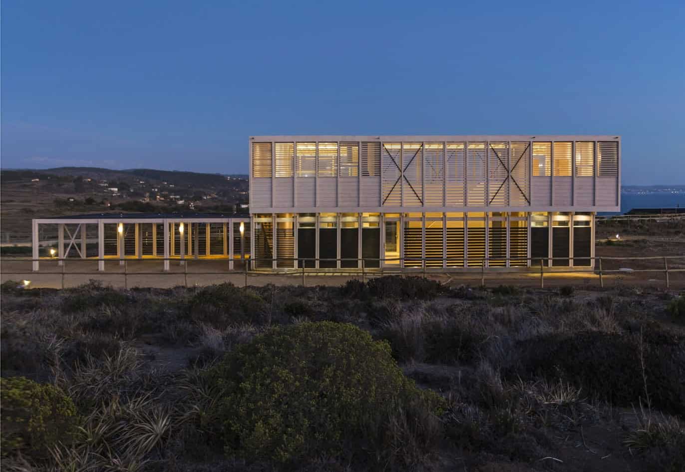 Modern architectural design of a contemporary building with innovative facade elements and elegant lighting at dusk, showcasing unique structure and sleek landscape integration.
