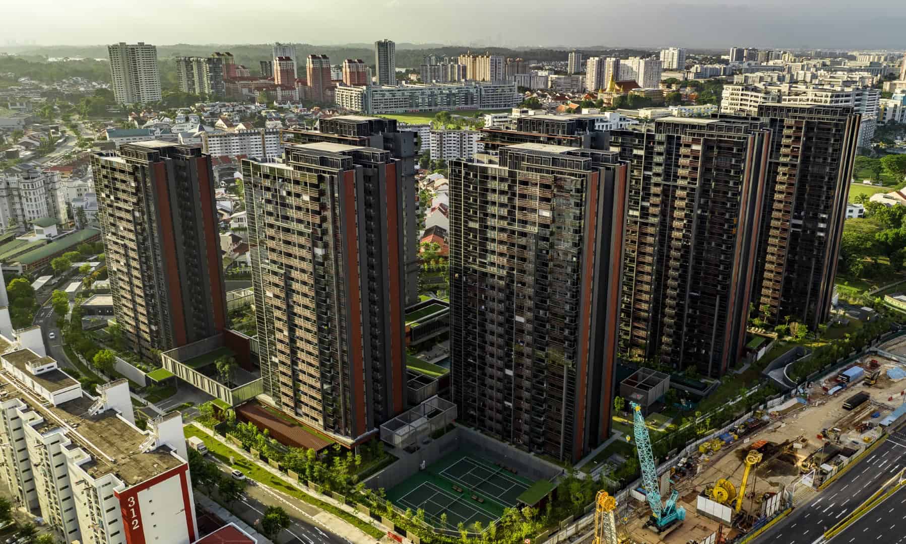 Modern high-rise residential buildings with contemporary architecture, surrounded by green spaces and urban development in a cityscape.