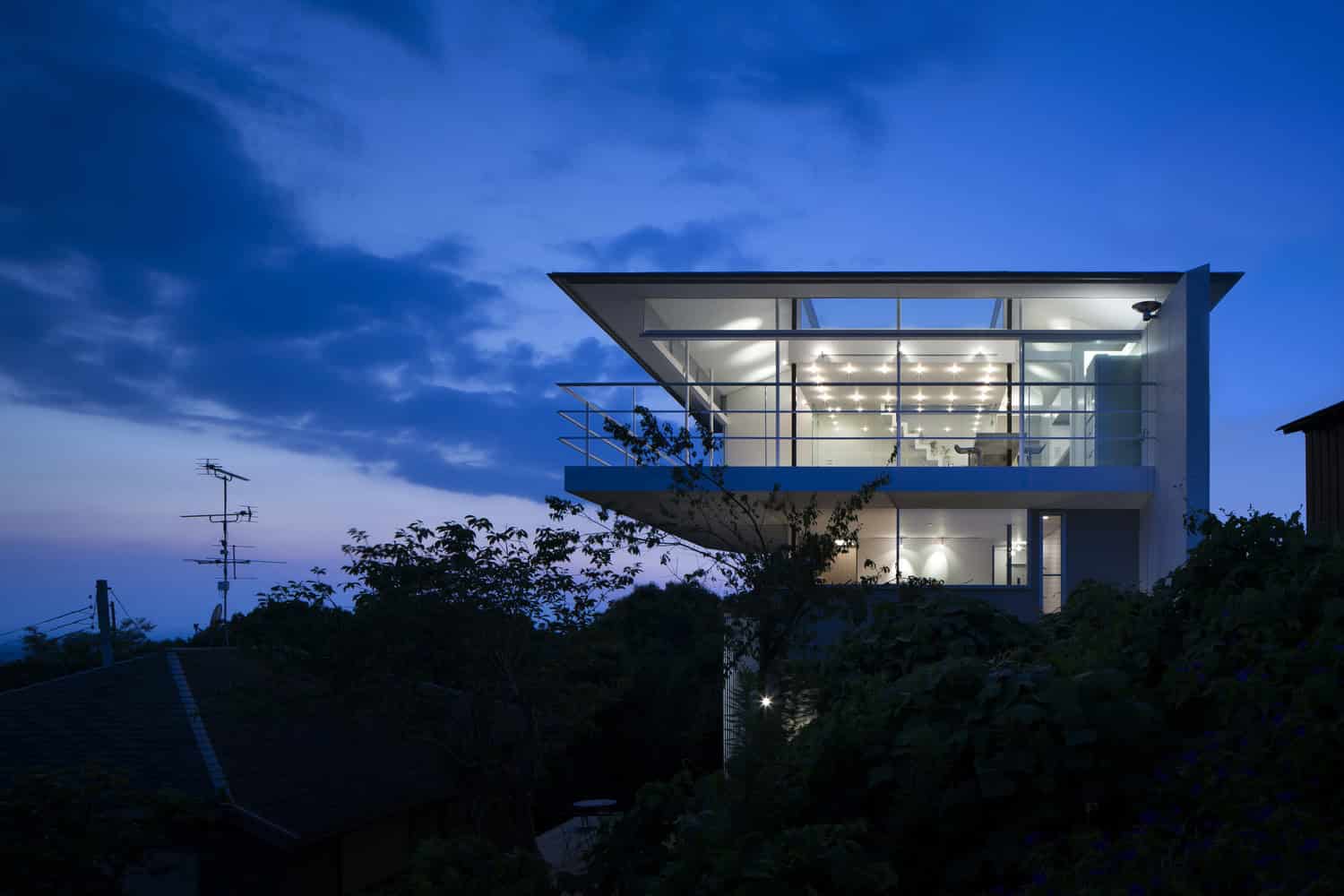 Ultra-modern glass house with sleek architectural design and illuminated interior at dusk serving contemporary architecture and home design inspiration.