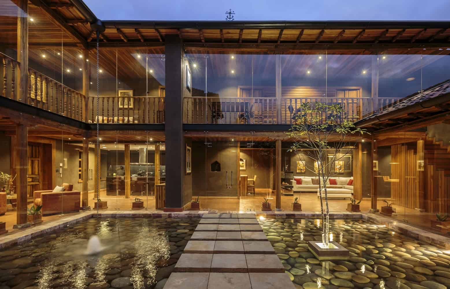 Luxurious modern house interior with wooden accents, glass walls, and a serene pond, showcasing contemporary architecture and elegant design elements.
