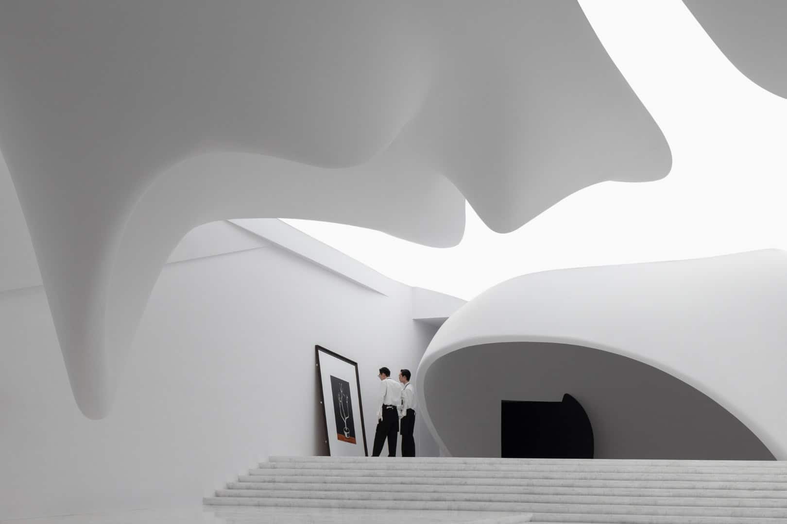 Futuristic white architecture interior with flowing organic curves and modern design elements, showcasing innovative architectural art and design features.