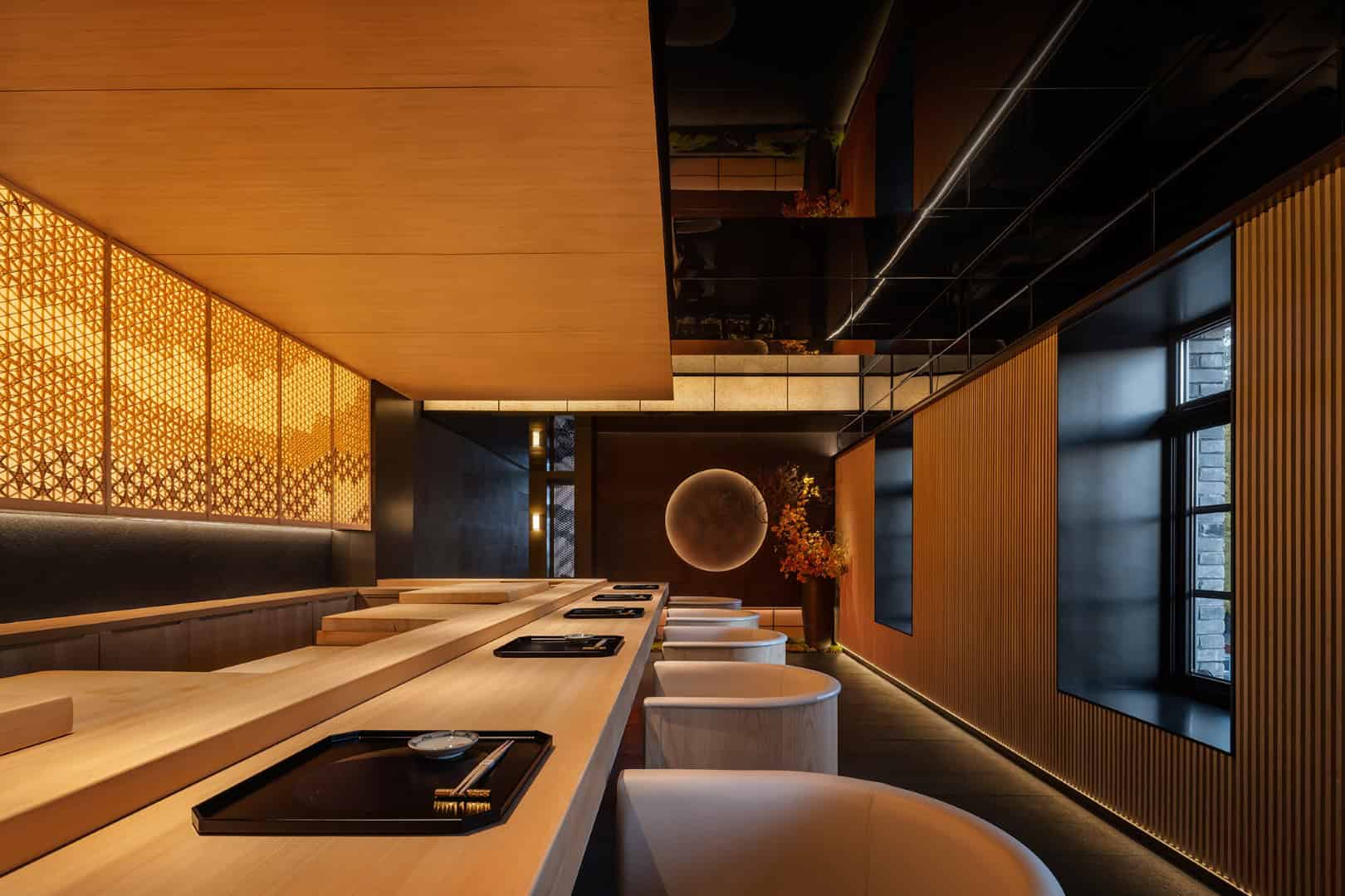 Elegant modern restaurant interior with warm wood accents and ambient lighting, showcasing contemporary architecture and stylish furniture design.