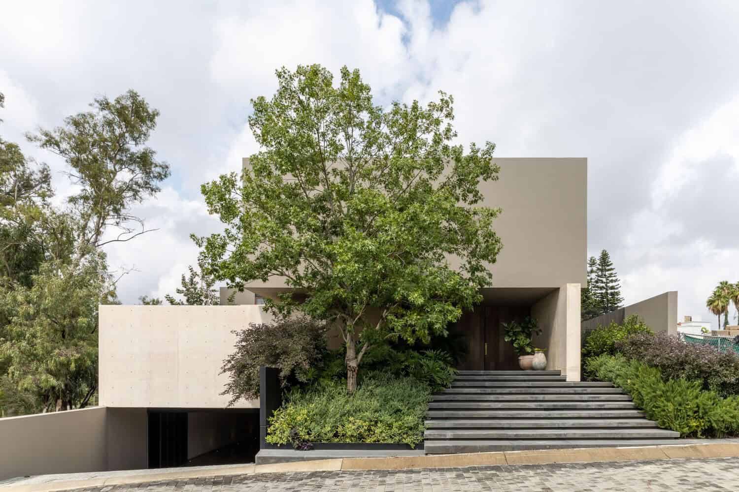 Luxurious modern house with minimalist concrete facade and lush green landscaping, showcasing contemporary architecture and innovative design.