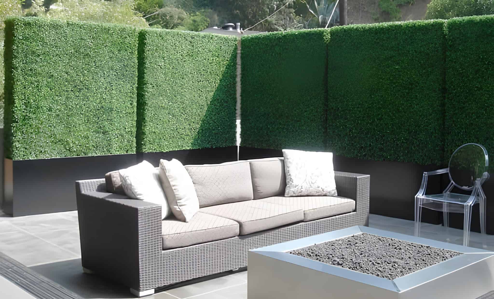 Hedge-style green wall privacy screen behind modern outdoor seating