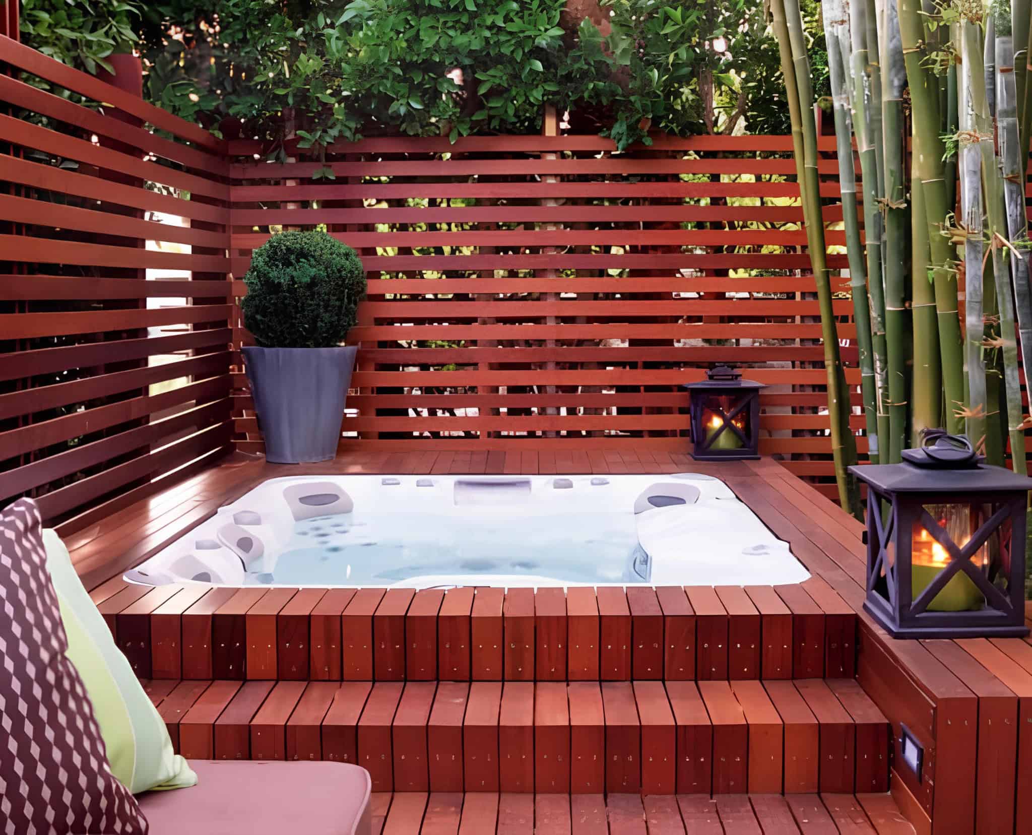 Redwood privacy slats surrounding a cozy hot tub nook with lantern lighting