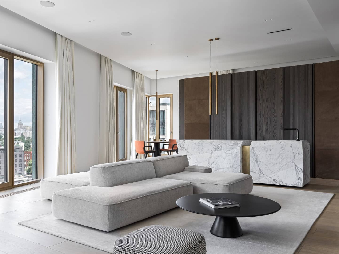Contemporary living room with minimalist design, large windows, and modern furniture including a gray sectional sofa and marble accents, showcasing sleek architecture and interior style.