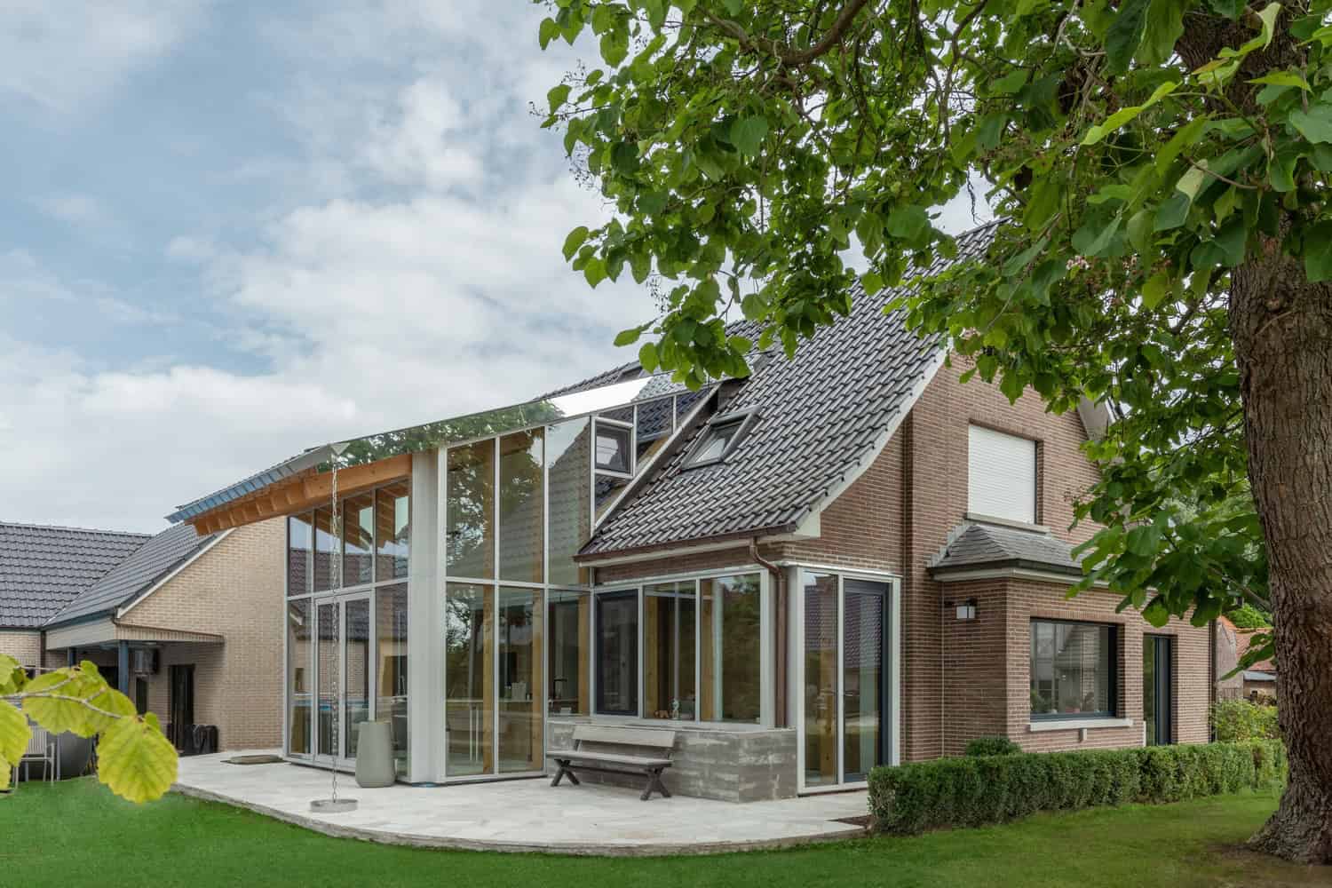 Contemporary residential house with modern architecture, large glass windows, and a mix of traditional brick and innovative design elements. Perfect for modern home design enthusiasts.
