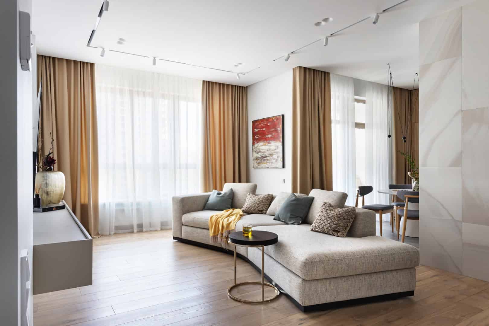 Modern living room interior with beige sofa, contemporary design, large windows with sheer curtains, stylish artwork, and minimalist decor for elegant home architecture and interior design.