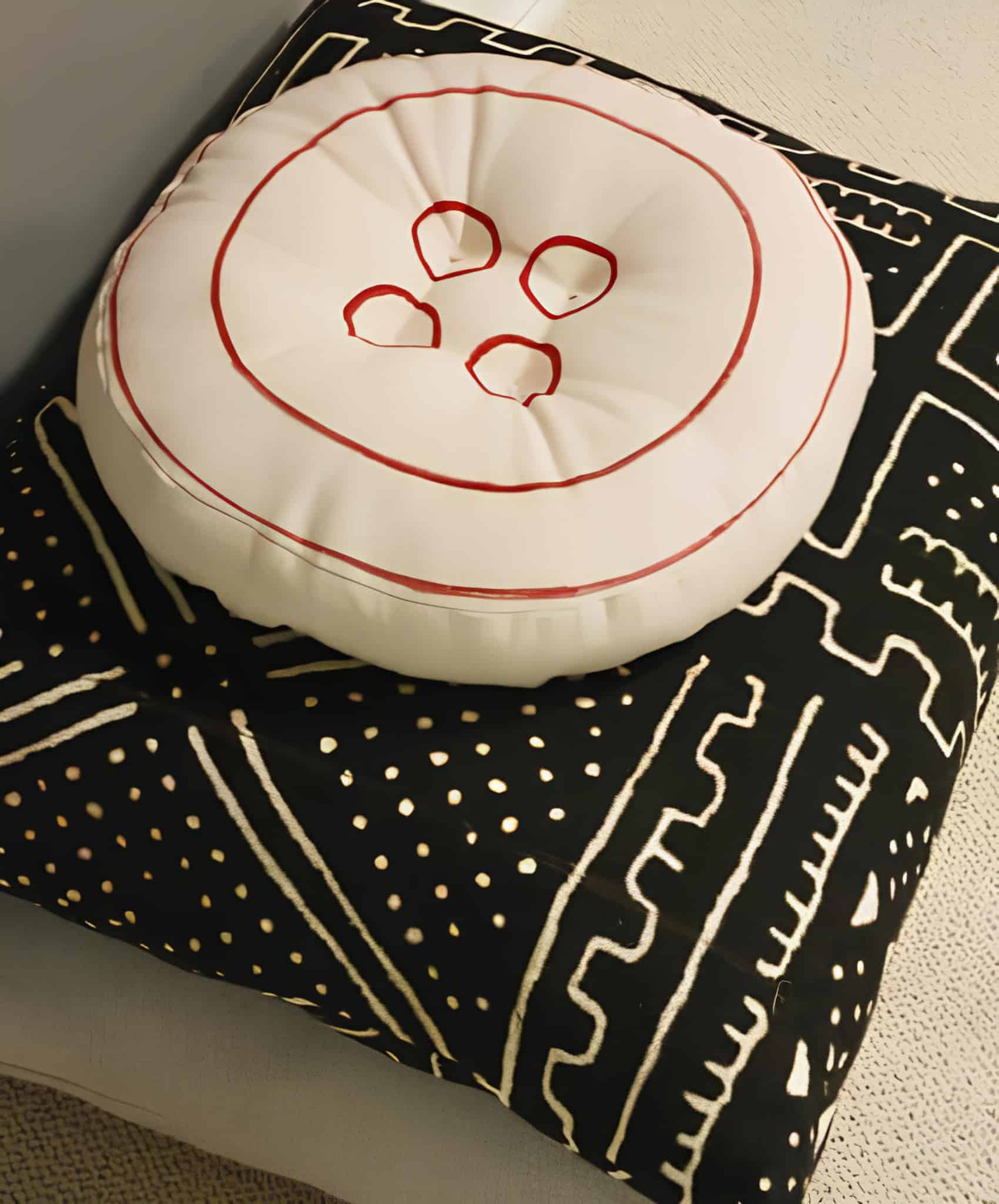 Button Pillow and Patterned Floor Cushion Creative pillow styled like a button paired with a bold graphic floor cushion