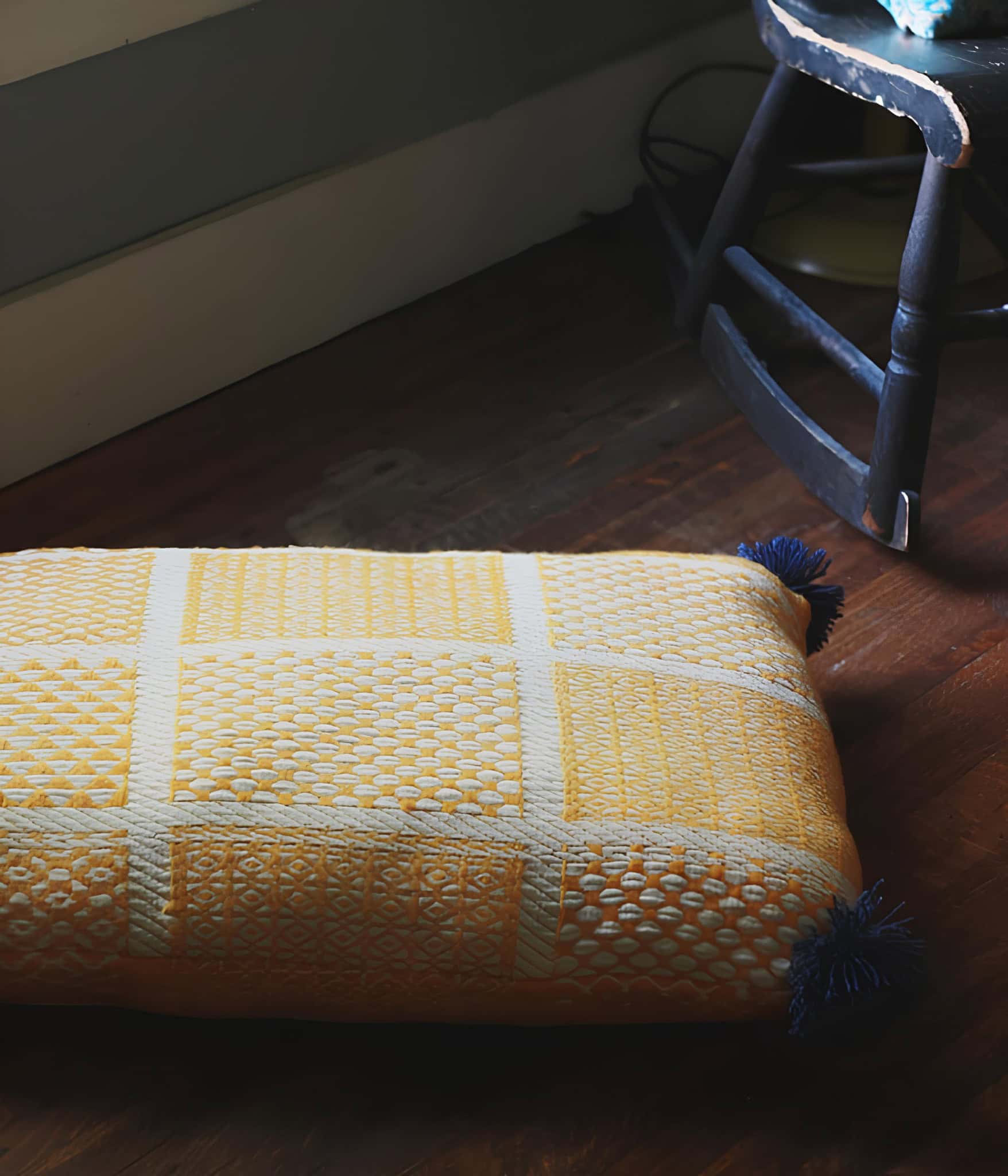 Yellow Checkered DIY Floor Cushion with Tassels Yellow floor cushion with white checkered design and tassels in a cozy room