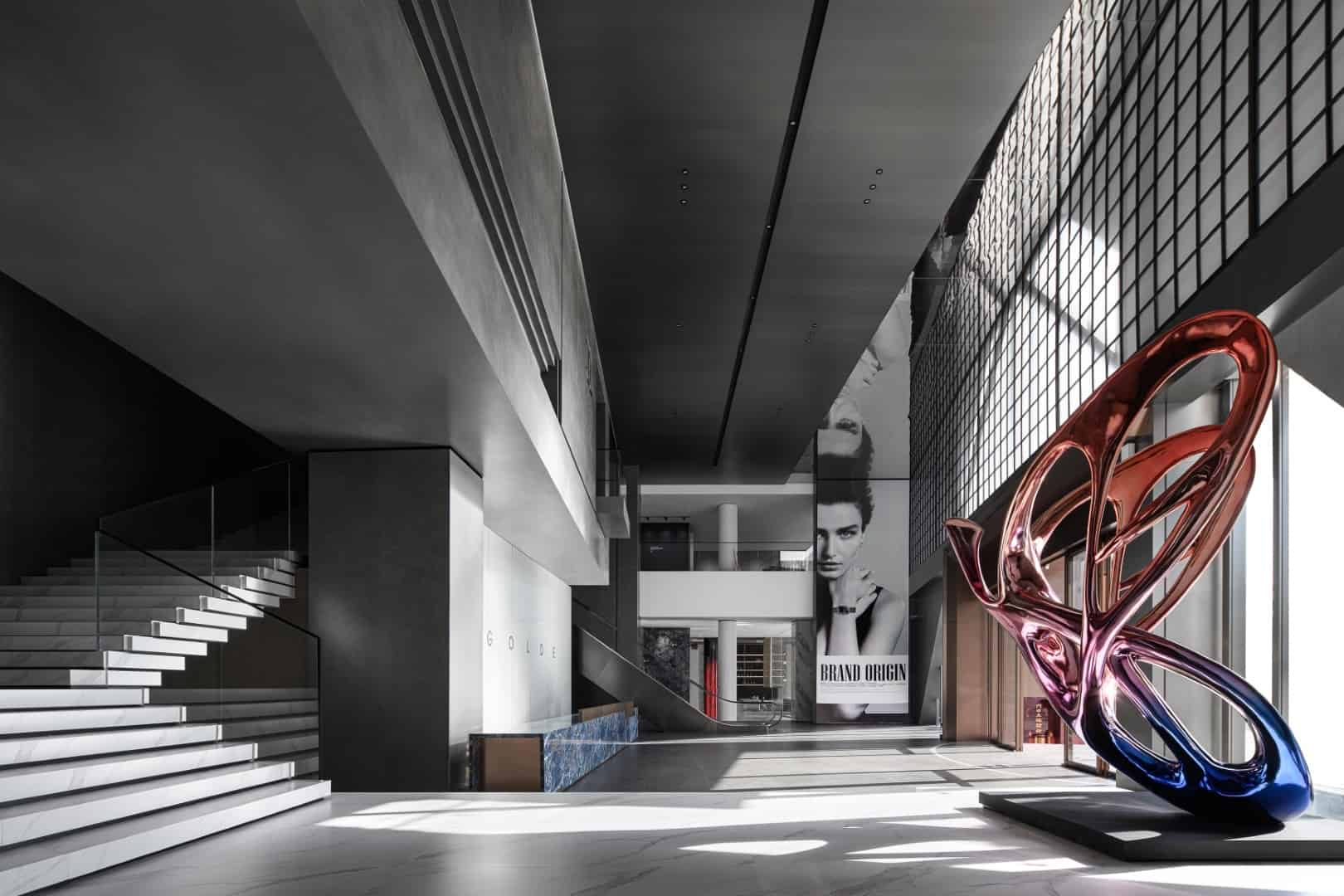 Stunning modern interior of a contemporary building featuring sleek black and white design elements, a colorful abstract sculpture, and large promotional posters capturing innovative architecture art designs.