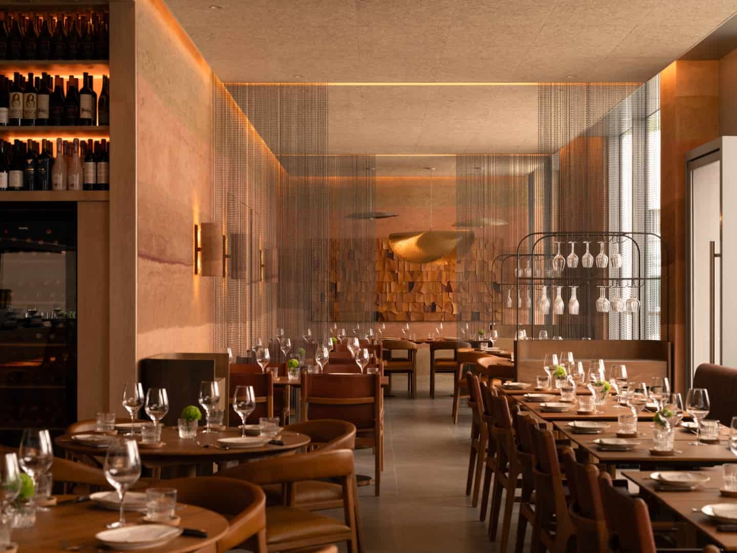 Elegant modern restaurant interior with warm wooden accents, ambient lighting, and stylish table settings offering a luxurious dining experience.