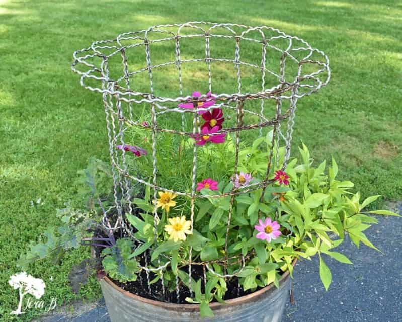3. Repurposed Garbage Can Planter with Vintage Fencing 3. Repurposed Garbage Can Planter with Vintage Fencing