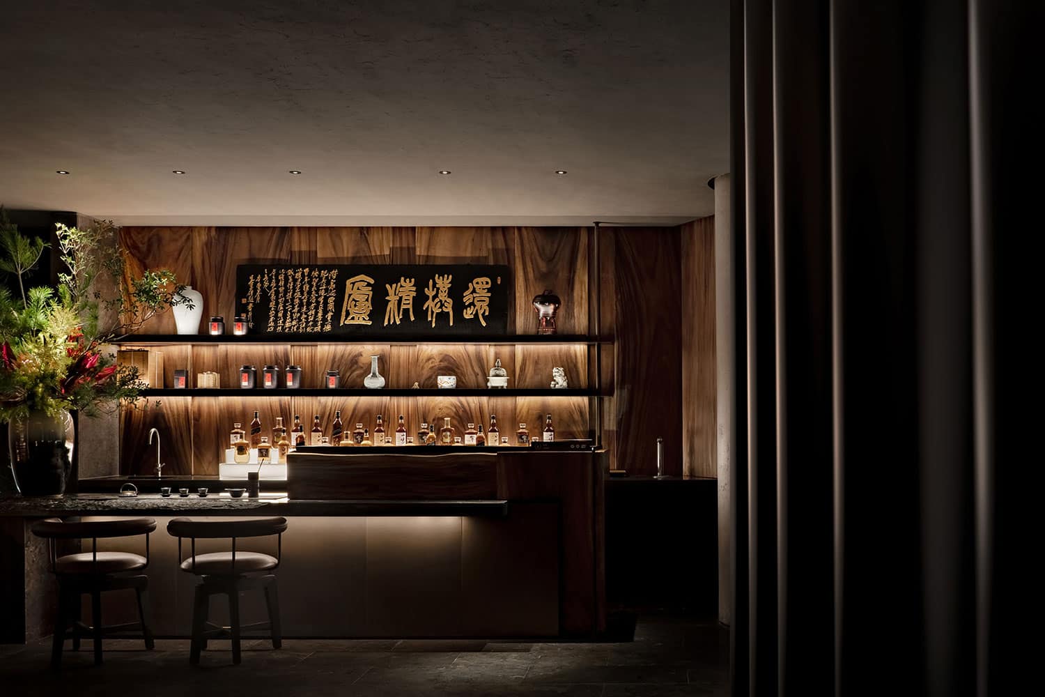 Sleek modern bar interior with warm wood finishes, ambient lighting, and Asian-inspired decor showcasing stylish design and luxurious atmosphere.