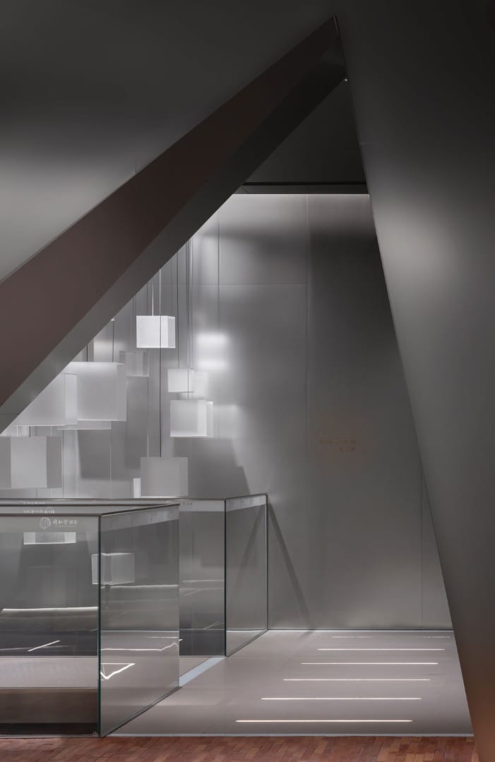 Calibrated Threshold Stone and mirror threshold offering a tactile pause between major exhibit chapters.