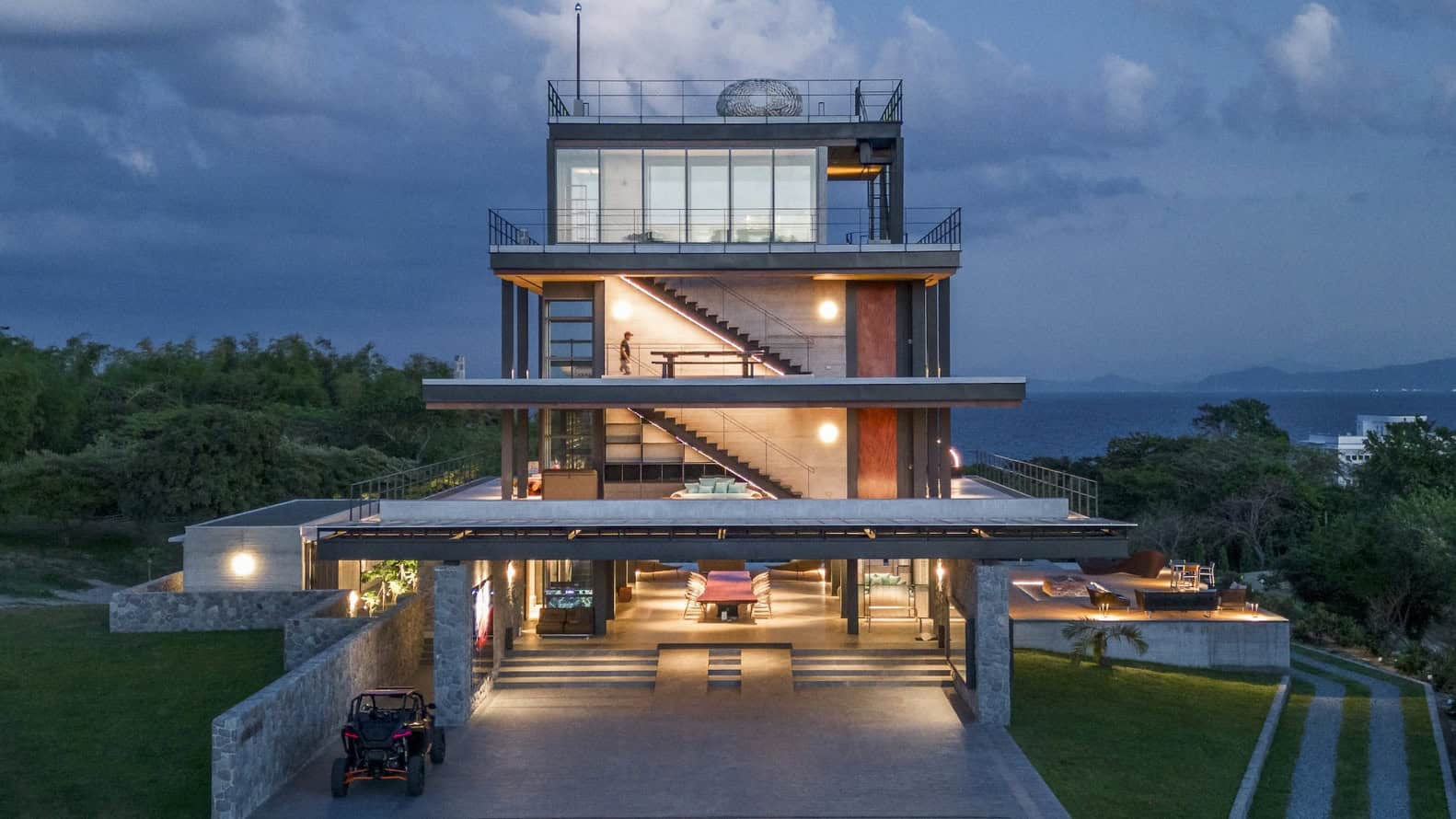 Modern multi-story ocean view house with contemporary architectural design and extensive outdoor terraces at dusk.