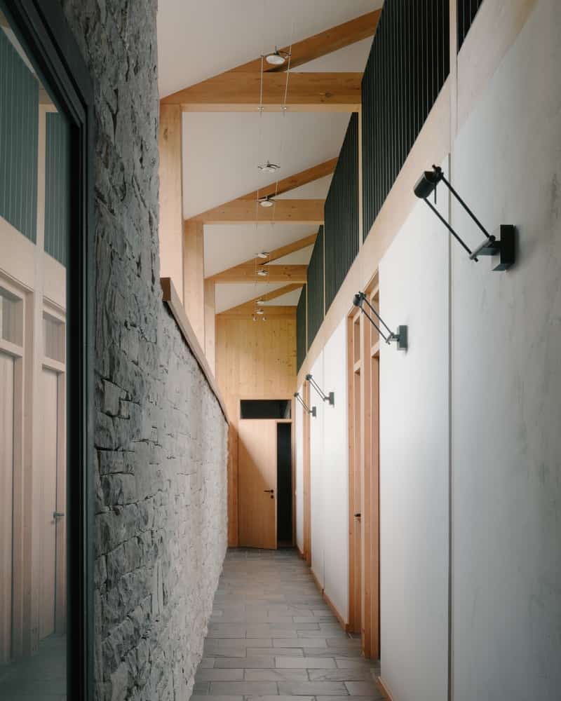 Clerestory Light & Quiet Rooms Bedroom corridor with clerestory windows washing stone and timber surfaces in soft light.