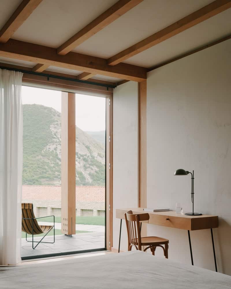 Dining with a View Dining area oriented to hillside views, combining warm timber ceilings with glazed walls.