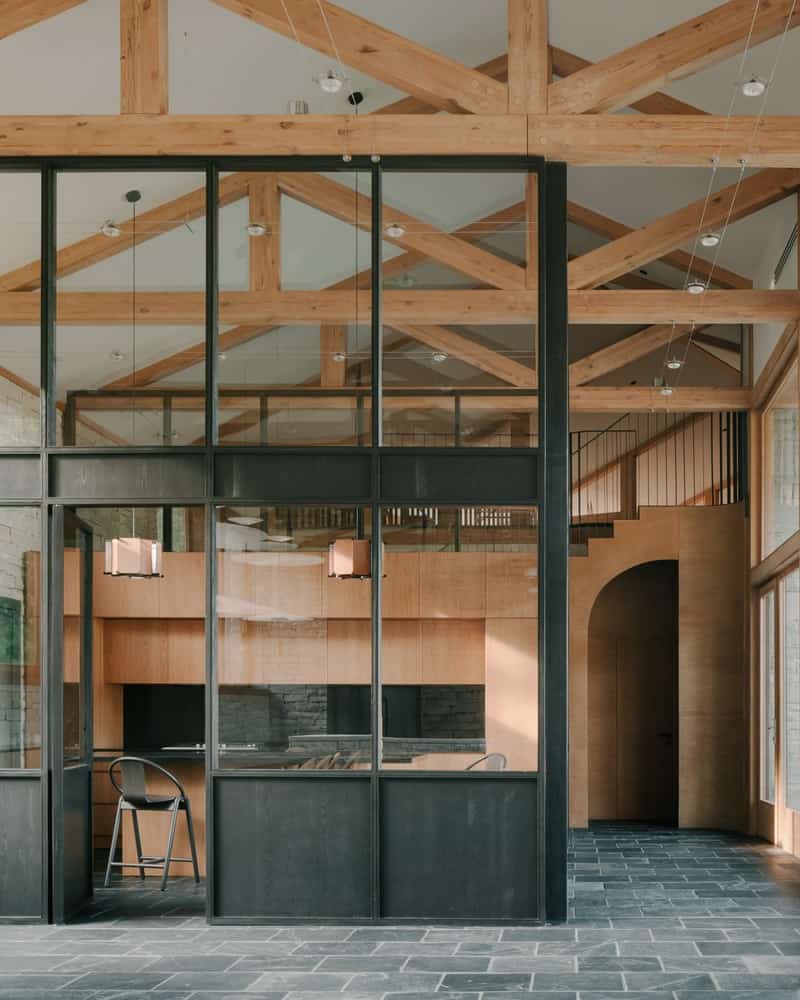 Stone, Timber, Sky Oblique exterior showing stone massing, timber eaves, and sky reflections in glass.