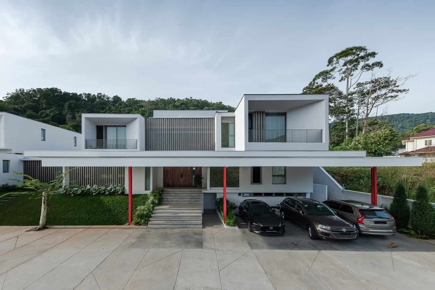 Modern minimalist residential house with geometric design and clean lines, featuring white exterior, spacious balconies, and large windows.