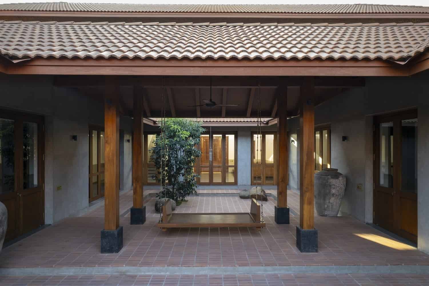 House, Courts, Fields Wide view of the house sitting low in farmland with twin courts organizing the plan.