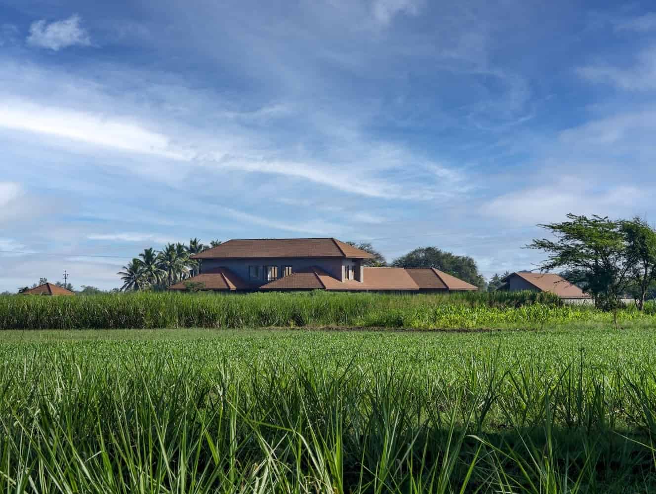 Arrival through the Front Court Stone-and-brick house with pitched roofs opening to a welcoming front courtyard in Phaltan.
