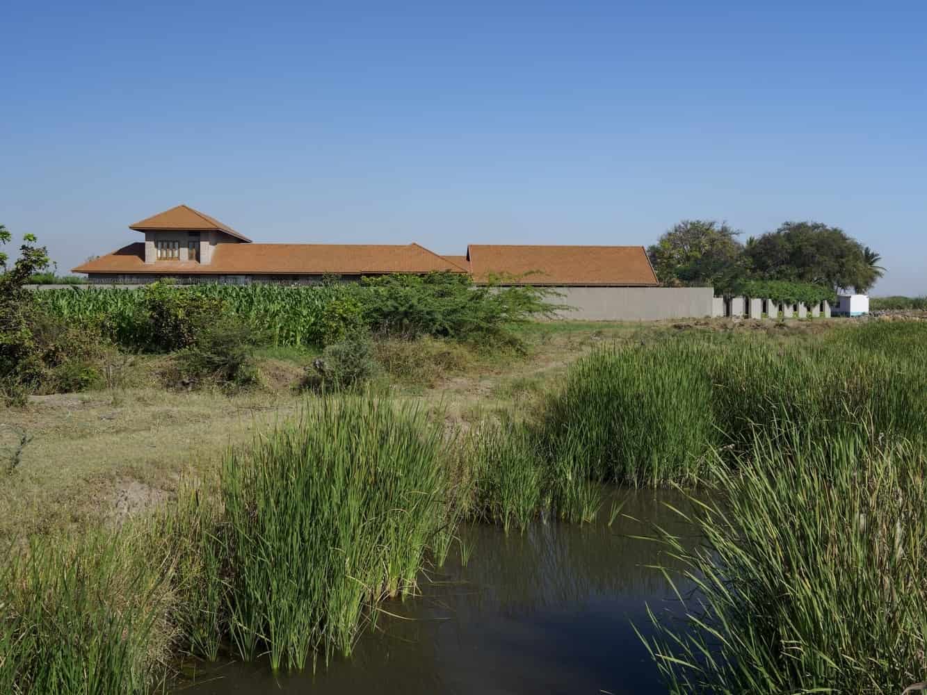Arc of Movement A verandah-lined passage curving from front to rear court, framing fields beyond.