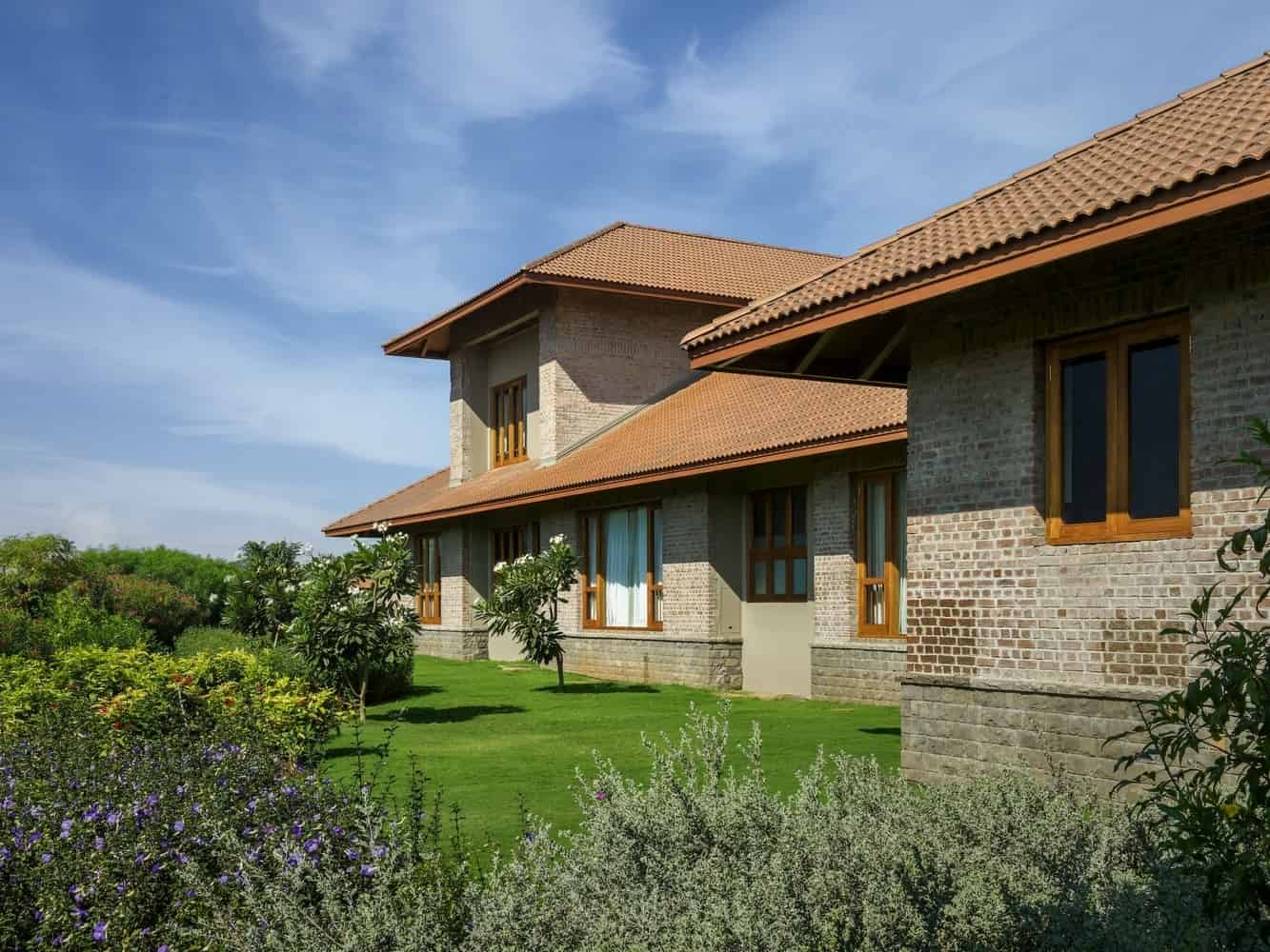 Verandah Thresholds Shaded verandah between court and garden with stone paving and timber eaves.