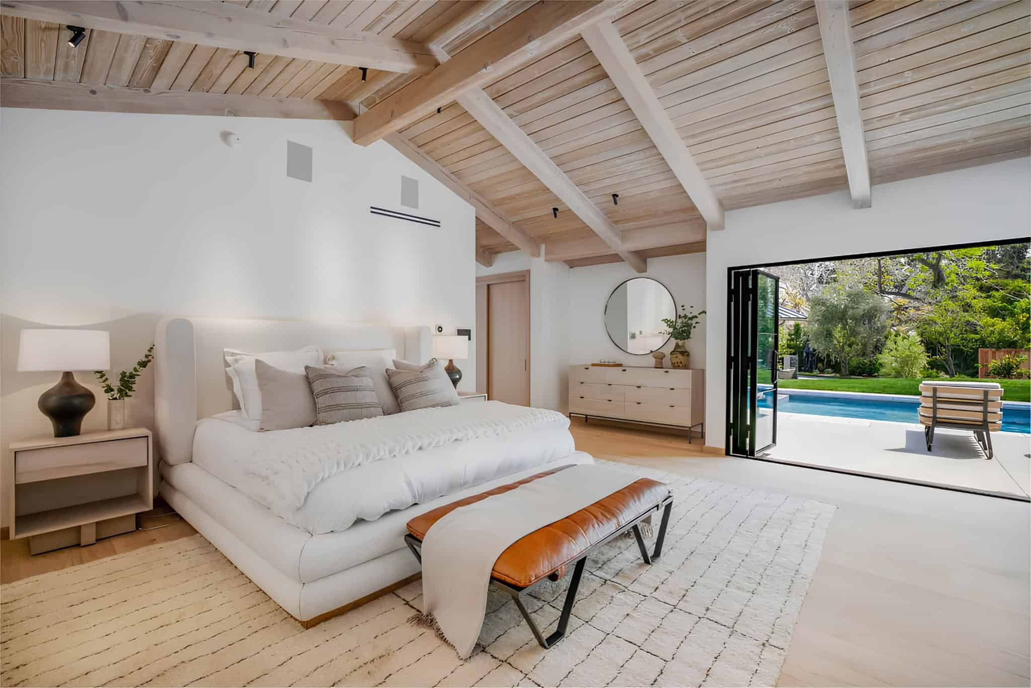 Mediterranean Bedroom Los Angeles Stylish bedroom with dark tufted headboard and floor-to-ceiling windows.