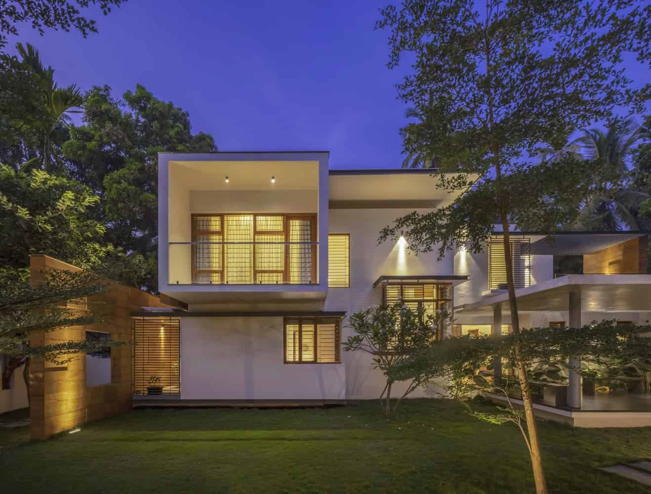 Luxury modern house with minimalist architectural design and large windows, surrounded by lush greenery and outdoor lighting. Perfect for contemporary urban living and innovative home design.