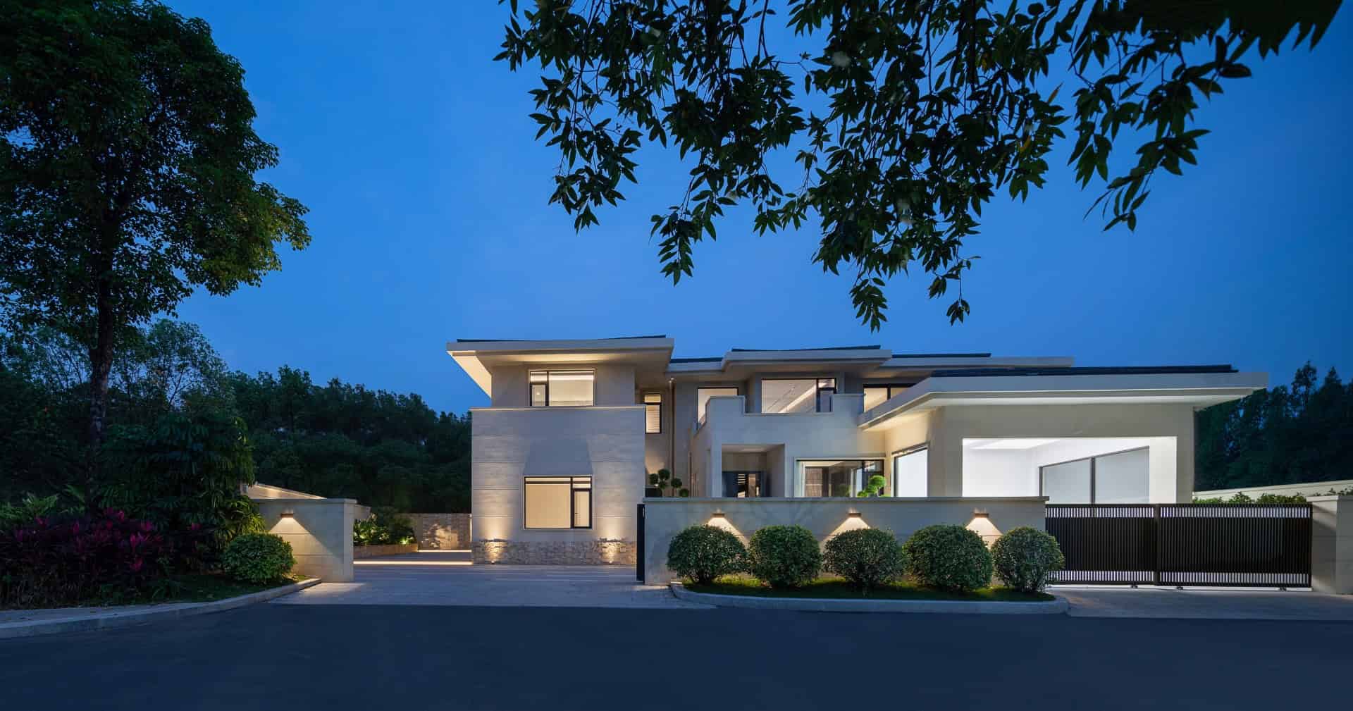 Luxurious modern house with sleek architecture illuminated at dusk, featuring clean lines, large windows, and contemporary design elements for upscale residential appeal.