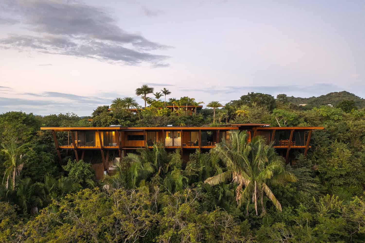 Modern treehouse designed with natural wood materials nestled among lush tropical greenery, offering a luxurious and eco-friendly architecture art design for nature lovers.