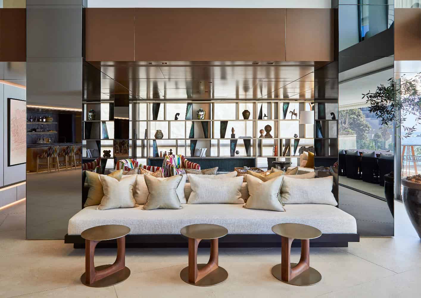 Elegant modern interior living room with beige sofa, contemporary decor, and open shelving filled with decorative items, emphasizing luxury home design and stylish architecture.