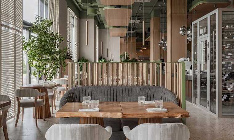 Cozy modern restaurant interior with wooden accents and lush green plants for elegant contemporary dining spaces.