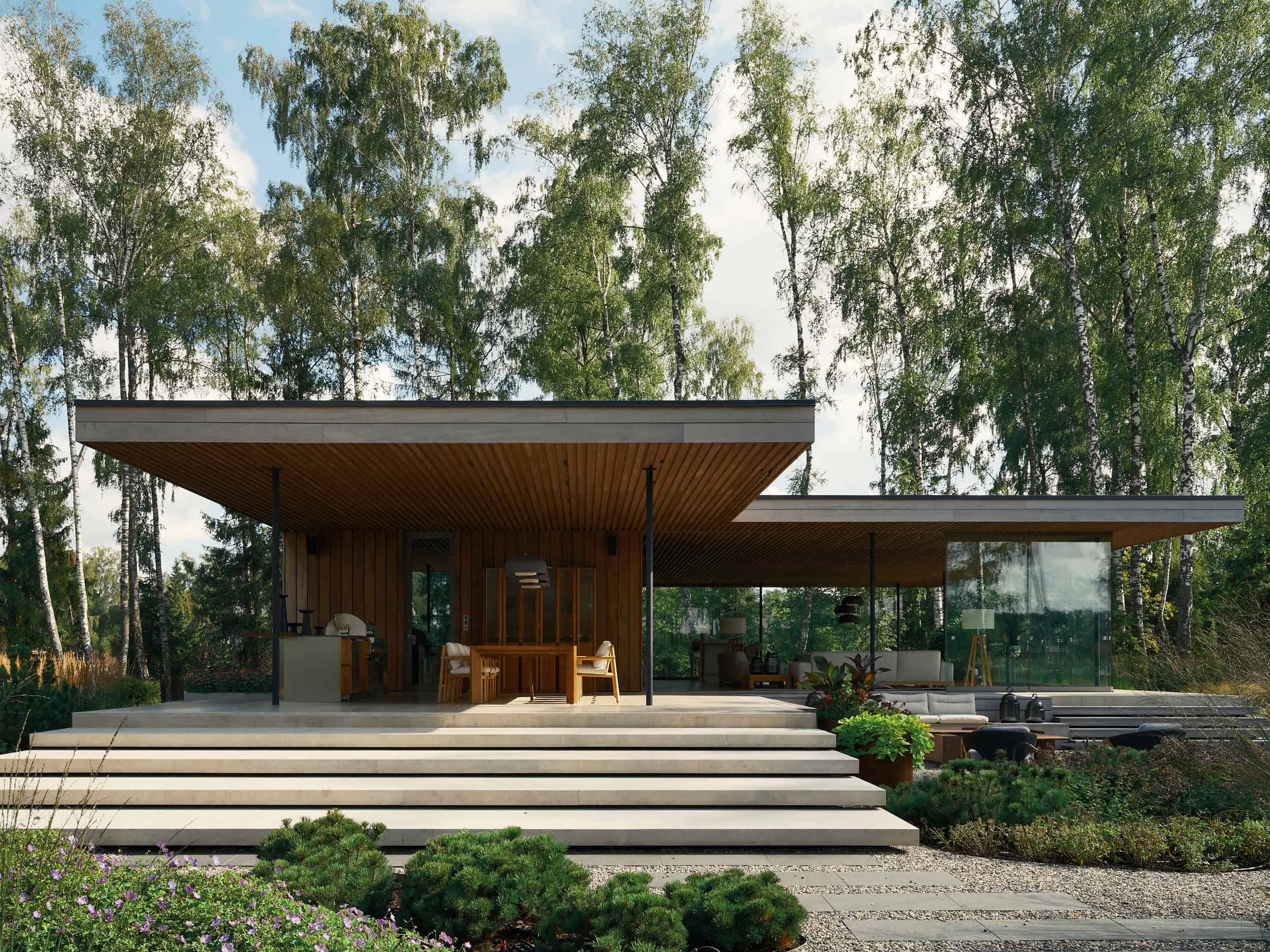 Contemporary modern house with sleek design, large glass windows, and spacious outdoor patio surrounded by greenery and trees, showcasing innovative architecture and stylish outdoor living spaces.