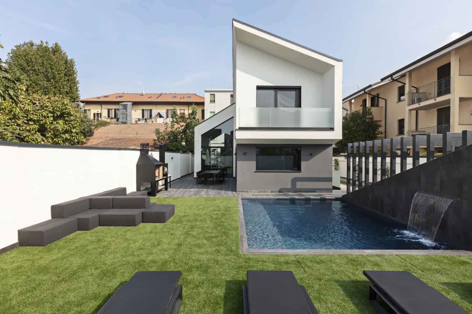 Modern minimalist house with sleek geometric architecture and outdoor swimming pool, featuring contemporary design, clean lines, and an inviting backyard space, perfect for modern luxury living.