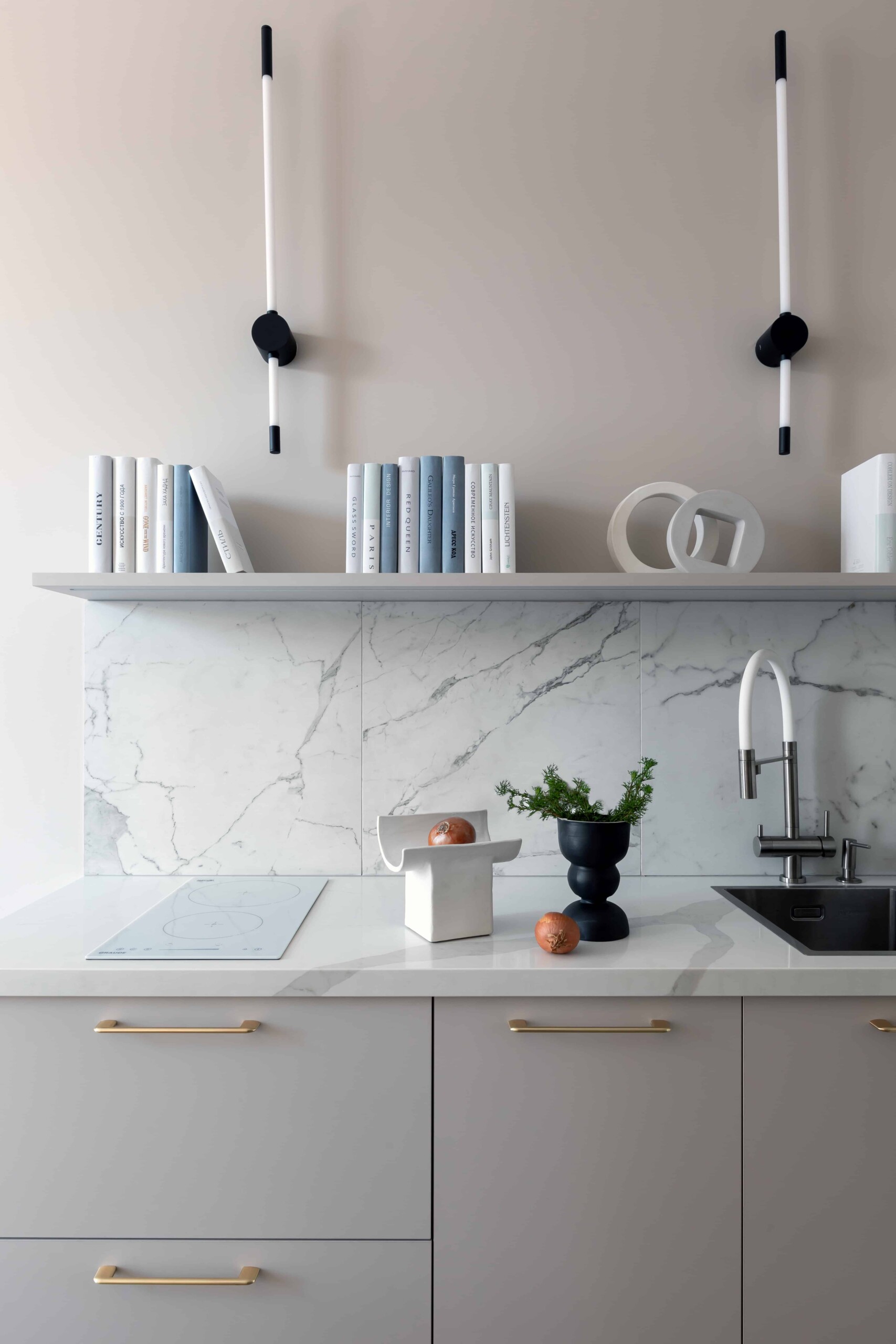 Sleek modern kitchen with marble backsplash, minimalist decor, and contemporary lighting fixtures emphasizing clean design and elegant aesthetics.