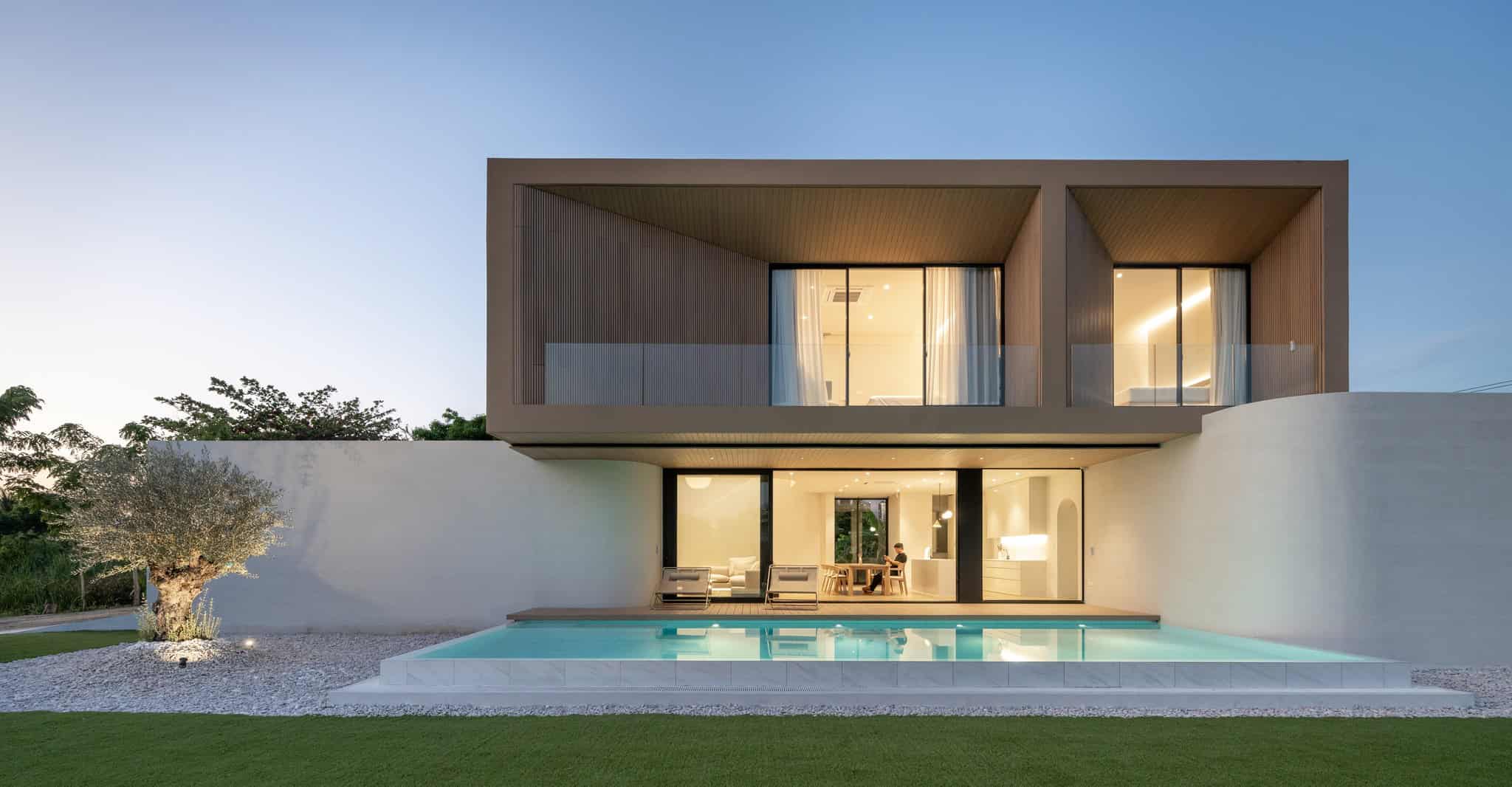 Modern minimalist two-story house with sleek design, large glass windows, and swimming pool in the backyard, showcasing contemporary architecture and stylish interior living space.