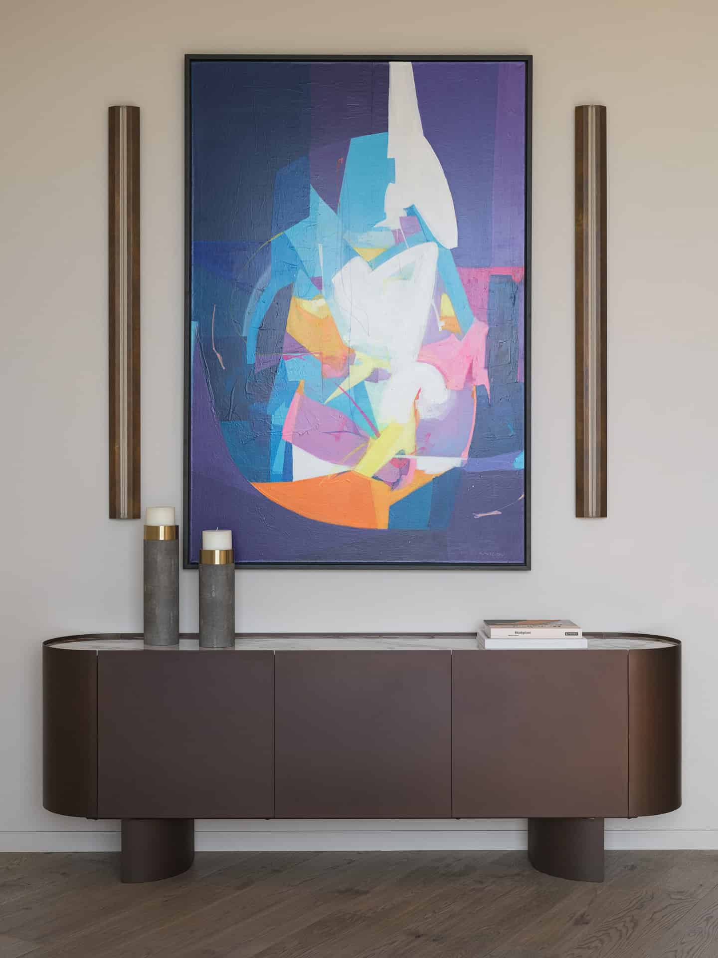 Abstract Art Over Modern Sideboard Modern sideboard with bold abstract painting and vertical sconces.